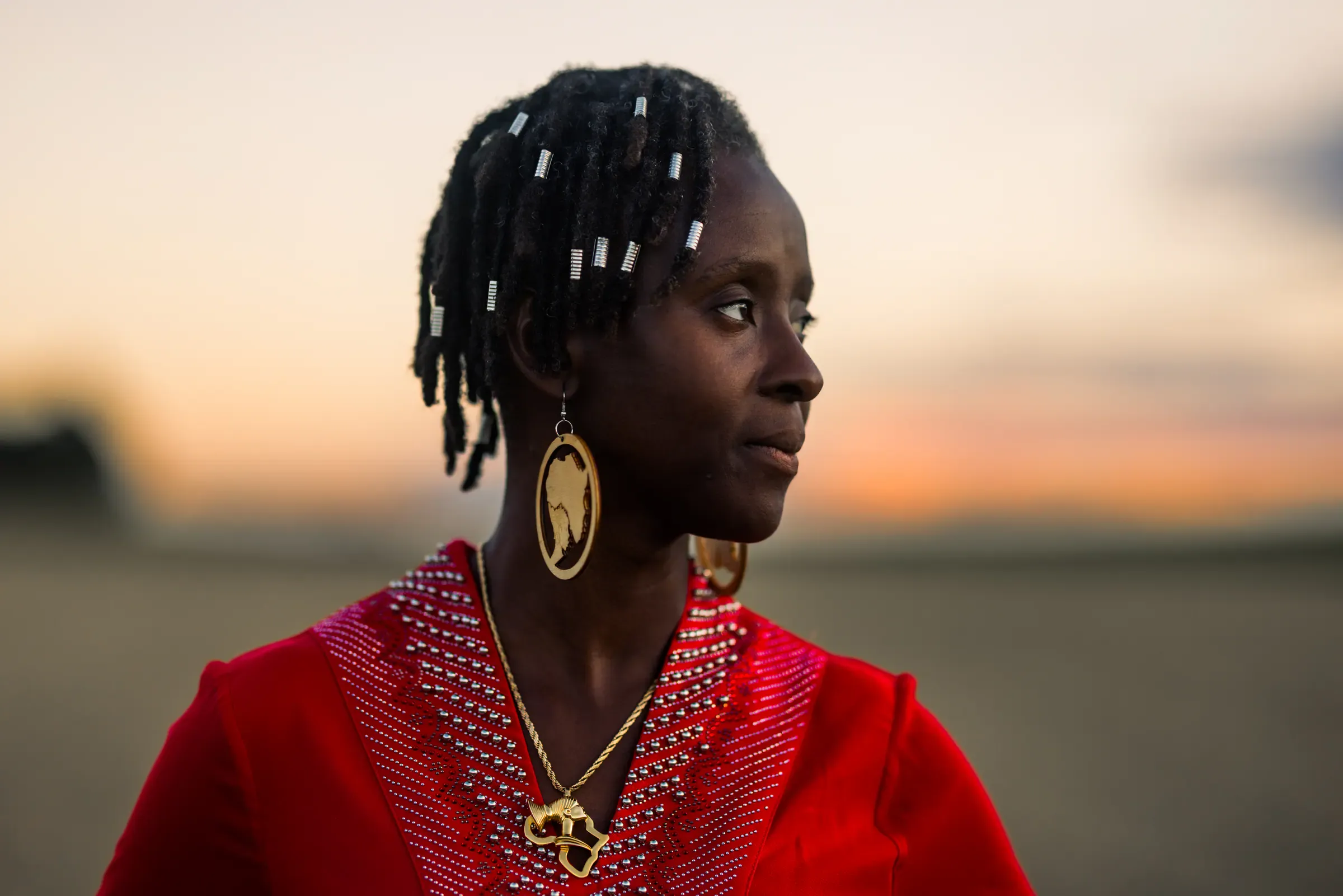 Portrait de femme en rouge, de profil, dans la lumière dorée du couchant