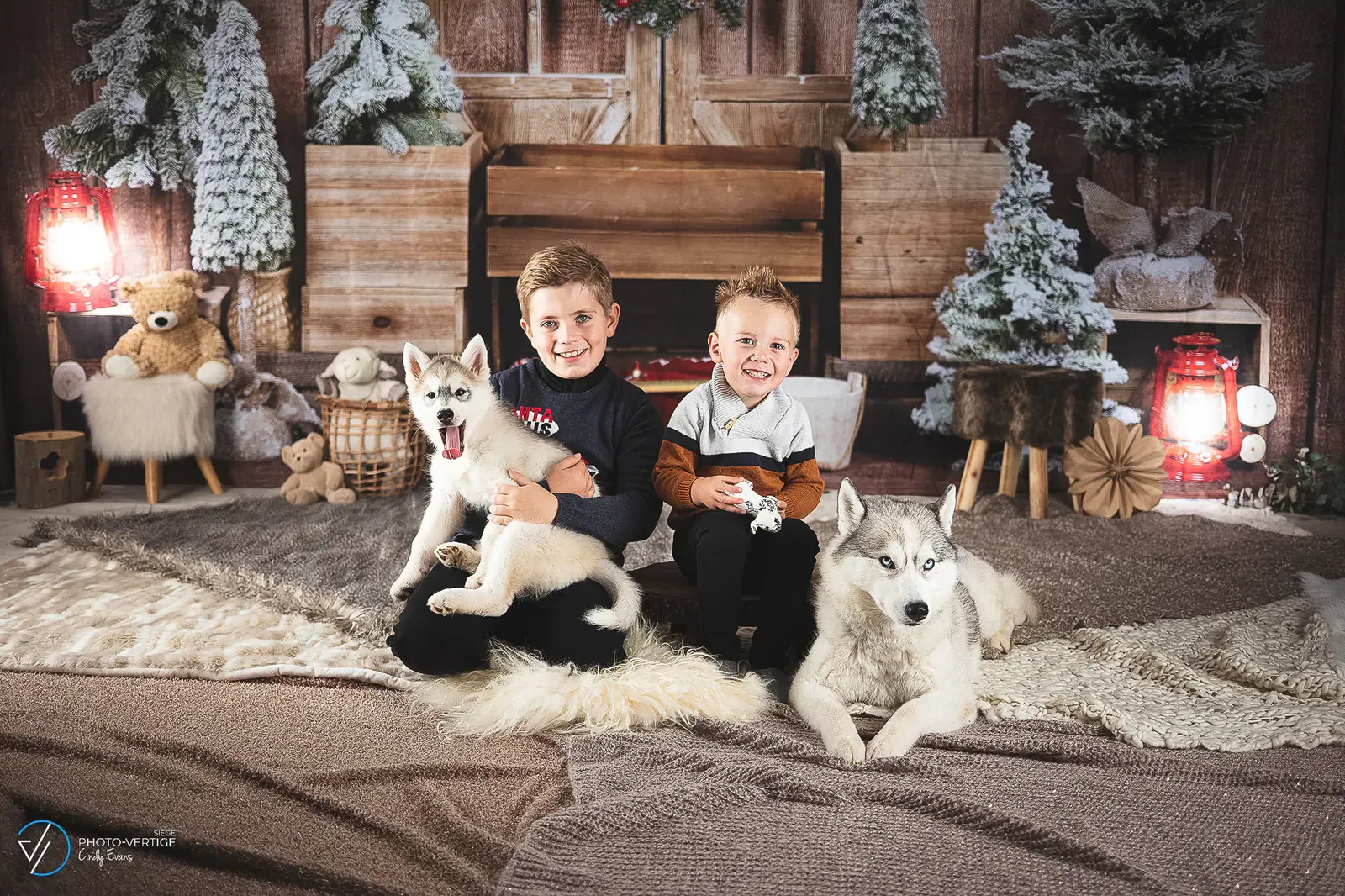 Deux enfants et des huskies dans un décor de chalet